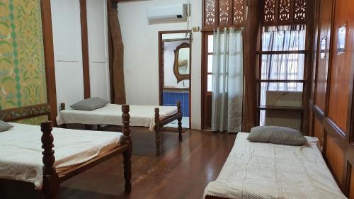 Zimmer mit 3 Betten und einem Spiegel in der Unterkunft Feelgood Whitesand Resort in Lapu Lapu City