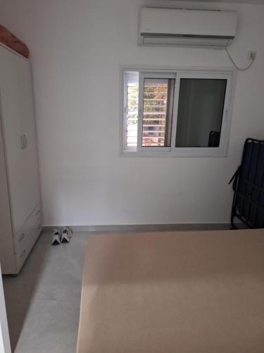 een kamer met een raam en twee paar schoenen bij המקום של אתי ולילך 2 in Eilat