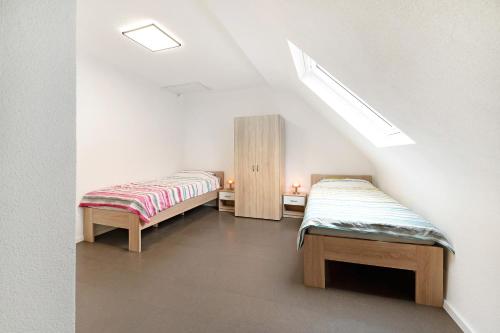 two beds in a room with a sloping ceiling at Christiane in Tholey