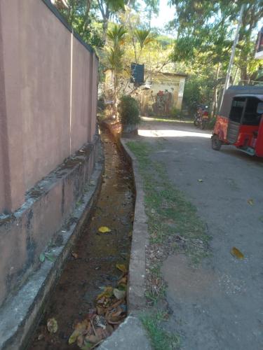 a wall next to a street next to a road at Trinish homestay in Hatton