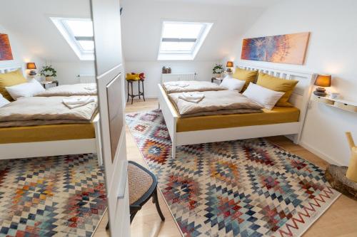1 dormitorio con 2 camas y alfombra en Schloßberg-Domizil mit Weitblick - Arbeitsplatz, Balkon, Netflix, Badewanne & Yogamatte, en Chemnitz