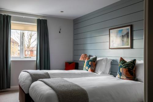two beds in a room with blue stripes at The Bridge Hotel in Chertsey