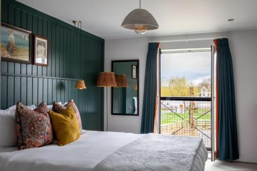 a bedroom with a bed with a green wall at The Bridge Hotel in Chertsey