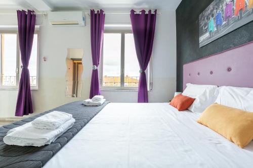 ein Schlafzimmer mit einem großen Bett mit lila Vorhängen in der Unterkunft Roma Vatican in Rom