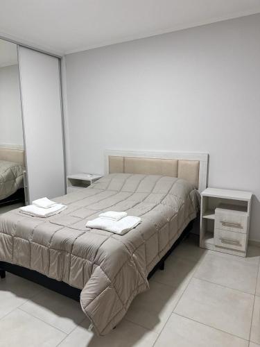 um quarto com uma cama grande e toalhas em RIFFEL 2 em Aldea Camarero