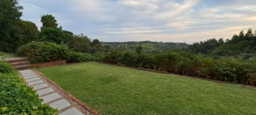 a garden with a large lawn and trees at Nature on your doorstep in Hoekwil