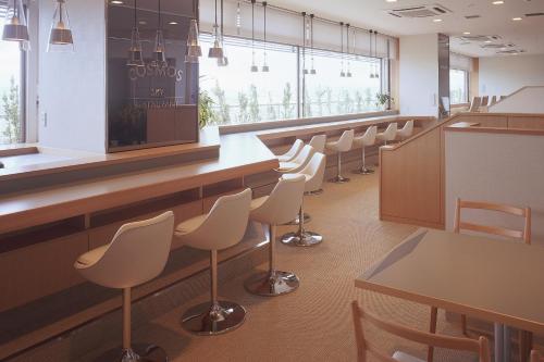 a waiting room with white chairs and a bar at Hotel Plaza Annex Yokote in Yokote