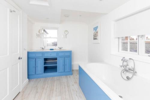 ein Badezimmer mit einem blauen Schrank und einem Waschbecken in der Unterkunft Independence House in Oakham
