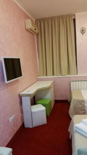 a hotel room with a desk and a tv in it at Hamlet Hotel in Bacău