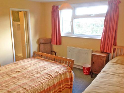 - une chambre avec un lit et une fenêtre avec des rideaux rouges dans l'établissement Cluaran Newport, à Newport