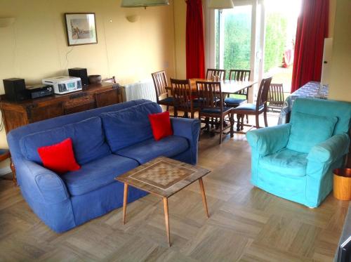 - un salon avec un canapé bleu, des chaises et une table dans l'établissement Cluaran Newport, à Newport