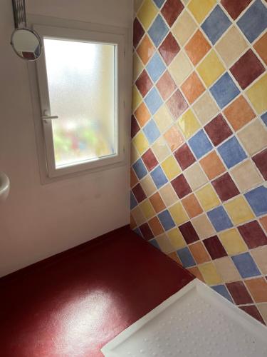 baño con ventana y pared de azulejos en Tita, en Manosque