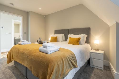 a bedroom with a large bed with towels on it at Bond House by Celador Apartments in Reading