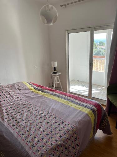 Un dormitorio con una cama con una manta de colores. en Tita, en Manosque