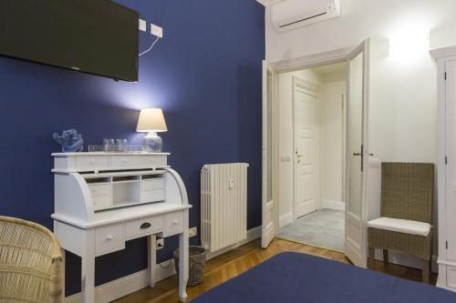 a room with a white desk and a blue wall at Household Settembrini in Milan