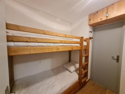2 Etagenbetten in einem kleinen Zimmer mit einer Tür in der Unterkunft Andromede - 90 - Appart renove 6 pers in Les Deux Alpes