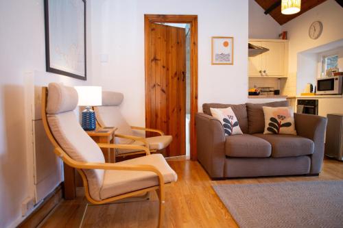 un soggiorno con un divano e una poltrona di Bay Cottage Little Haven a Little Haven