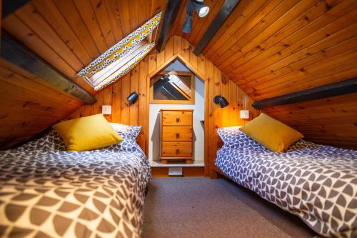 a bedroom with two beds in a wooden house at Bay Cottage Little Haven in Little Haven