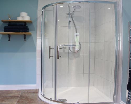 a shower with a glass door in a bathroom at The Hideaway Brongest in Troedyraur