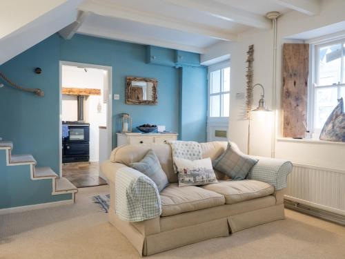 un soggiorno con divano e pareti blu di Driftwood Cottage Llangrannog a Llangrannog