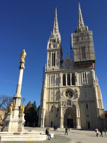 a large cathedral with a tower and a statue in front of it at Lovecroatia Zagreb - 'Pax nest' in Zagreb