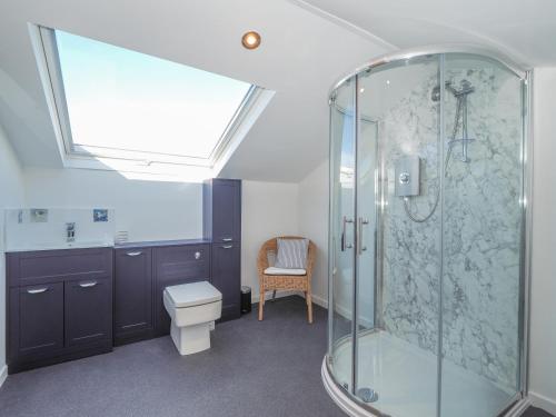 a bathroom with a glass shower and a toilet at Hiraul Aberporth in Aberporth