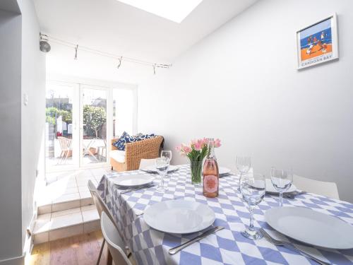 a dining table with a blue and white checkered table cloth at Brodawel New Quay in New Quay