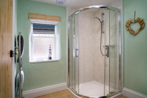 a shower stall in a bathroom with a window at The Old Stables Brongest in Troedyraur