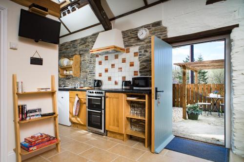 a kitchen with an open door leading to a patio at The Old Stables Aberporth in Troedyraur