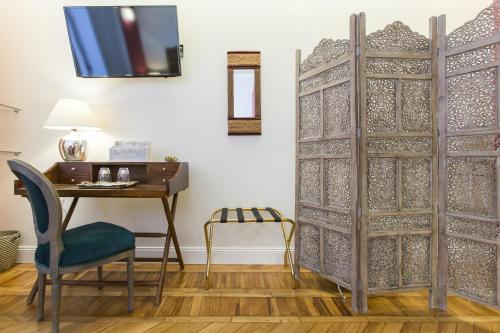 a desk and a chair next to a desk and a table and a door at Household Settembrini in Milan