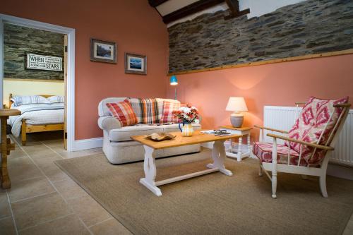 a living room with a couch and a table at The Old Stables Aberporth in Troedyraur