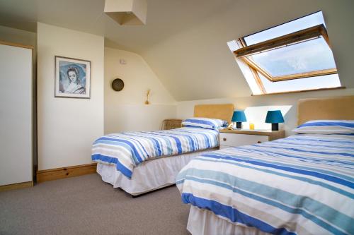 2 camas num quarto com uma clarabóia em Y Bwthyn St Nicholas em Saint Nicholas