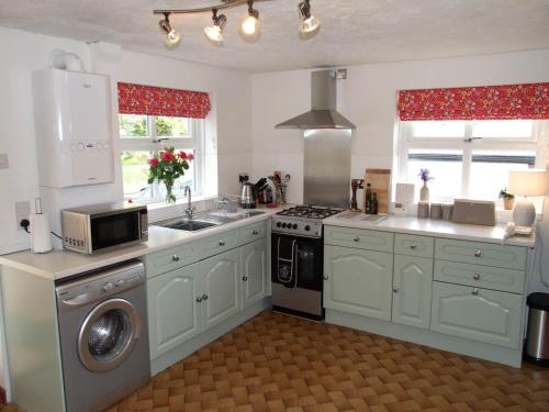 a kitchen with white cabinets and a stove top oven at Manchester House Narberth in Lampeter-Velfrey