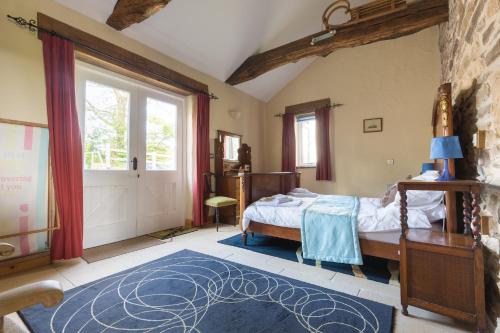 a bedroom with a bed and a large window at The Stables Newgale in Llandeloy