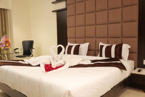 a bedroom with a large bed with a large headboard at HOTEL C COMFORT in Visakhapatnam