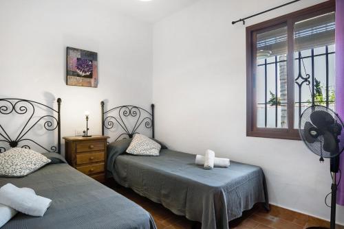 um quarto com 2 camas individuais e uma janela em Casa Ale em Cádis