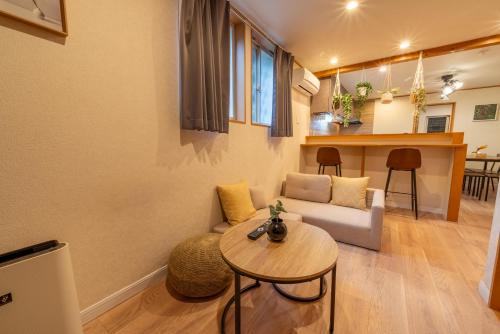 a living room with a couch and a table at New Open 天神橋筋六丁目駅徒歩1分 バーカウンター付き一軒家 天満居酒屋街徒歩3分 梅田 難波10分 in Osaka