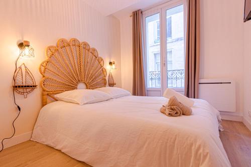 une chambre avec un grand lit blanc avec une grande fenêtre dans l'établissement Charmant T3 Neuf - Centre ville Décoration moderne, à Montpellier
