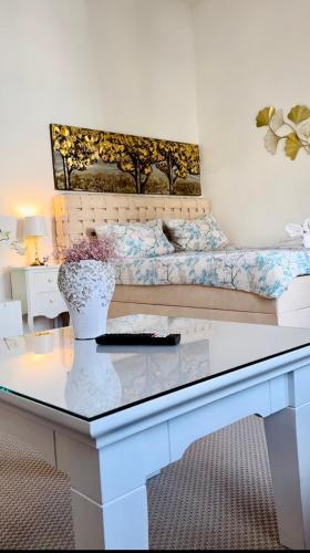 シュヴェリーンにあるWohnung am Schlossgartenのベッドルーム1室(ベッド1台、花瓶付きテーブル付)
