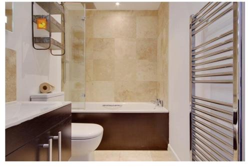 ein Badezimmer mit einem WC, einer Badewanne und einem Waschbecken in der Unterkunft Beach Penthouse Apartment Bournemouth in Bournemouth