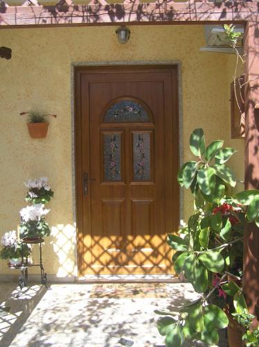 a wooden door with a window on a house at Il Fenicottero Elmas in Elmas