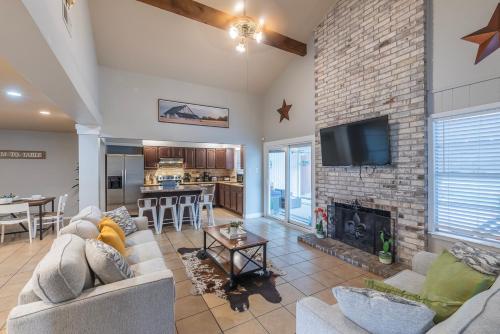 a living room with a fireplace and a stone wall at Pool, Gameroom & Minigolf Enchanting Texas Home in San Antonio