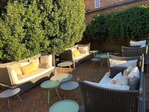 a group of wicker chairs and tables in a garden at Stylish Georgian Townhouse, Yorkshire - sleeps 12 in Easingwold