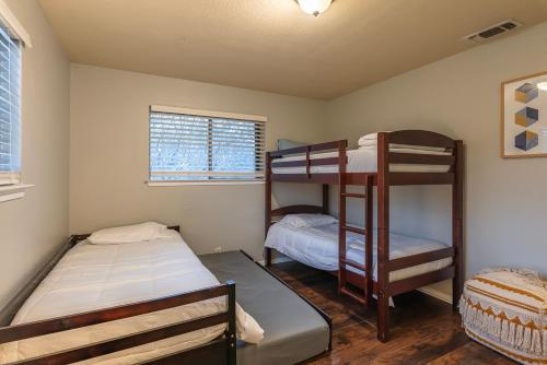 a bedroom with two bunk beds and a window at Pool, Gameroom & Minigolf Enchanting Texas Home in San Antonio