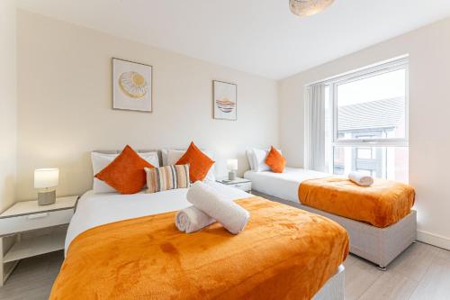 two beds in a bedroom with orange and white at Uni Utopia, Private Parking, Whole House in Tile Hill