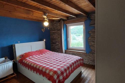 sypialnia z łóżkiem z czerwonym i białym kocem w obiekcie L'Ardoisière: jolie maison ardennaise. w Alle