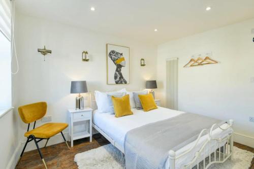 - une chambre blanche avec un lit et une chaise dans l'établissement North End House and Seven Acres Cottage, à Batheaston