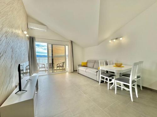 un salon avec une table et un canapé dans l'établissement Seaside Apartments Zlokovic, à Herceg-Novi