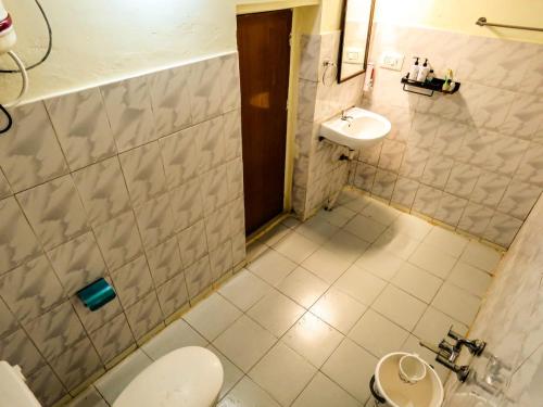 a bathroom with a toilet and a sink at BOB's Haven Bungalow in Ooty