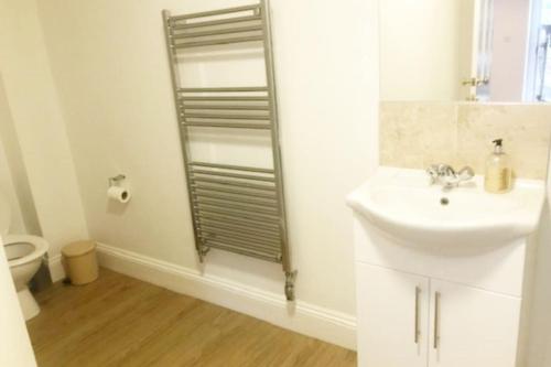 a white bathroom with a sink and a shower at Central Shaftesbury with private parking in Shaftesbury